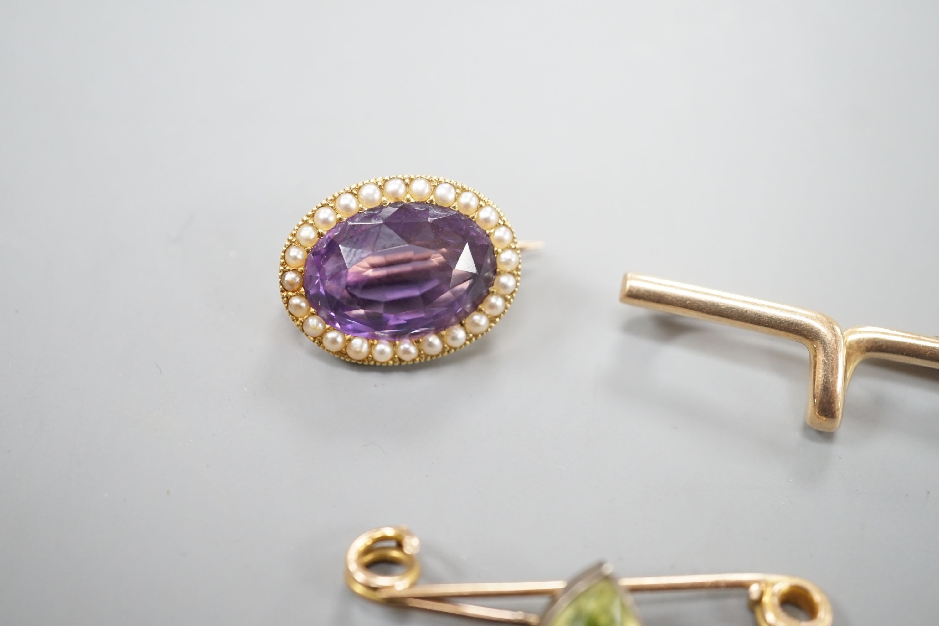 A yellow metal cravat pin, 37mm, a 9ct and heart shaped gem set bar brooch and a yellow metal, amethyst and seed pearl set oval brooch, gross weight 10.4 grams.